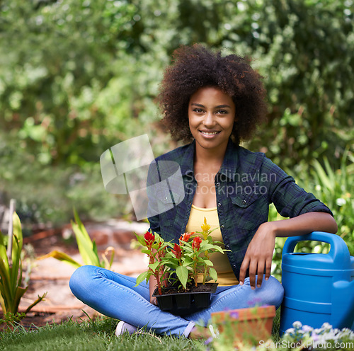 Image of Black woman in garden, smile while gardening with plant or flower, botany and young gardener in portrait outdoor. Happy female person with green fingers, growth and plants in nature with landscaping