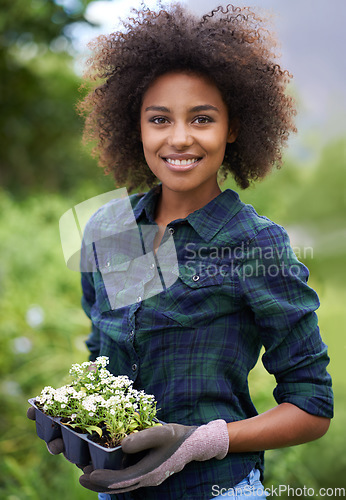 Image of Black woman with flower, smile while gardening and botany, young gardener in portrait with growth outdoor. Happy female person with green fingers, growth and plants in nature with landscaping