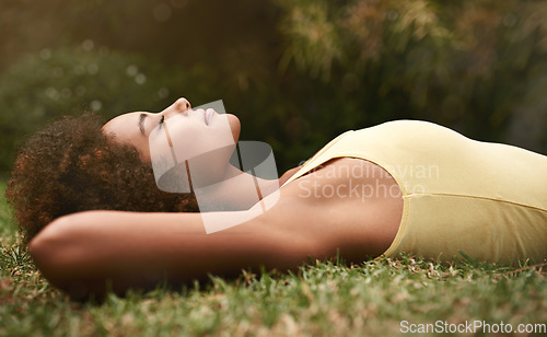 Image of Dreaming, grass and mockup with a black woman lying on a field for peace or quiet in nature during the day. Sleeping, relax and zen with an attractive young female resting alone in the countryside