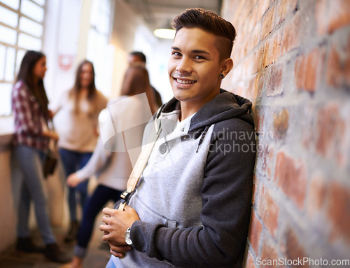 Image of Education, happy and portrait of man in college hallway for studying, learning and scholarship. Future, smile and knowledge with student leaning on brick wall for university, academy and campus
