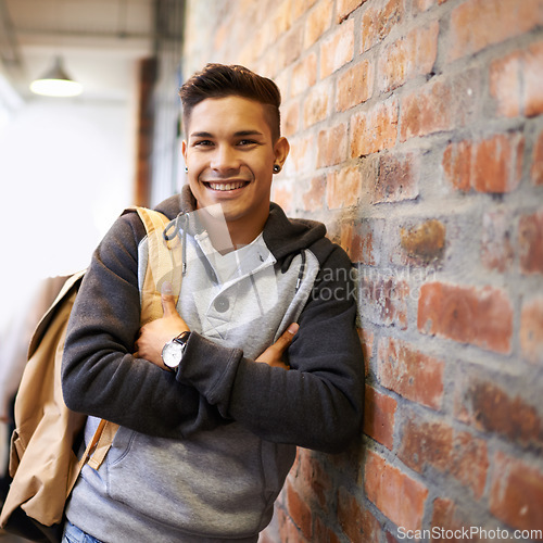 Image of Learning, smile and portrait of man in school hallway for studying, education and scholarship. Future, happy and knowledge with male student leaning on brick wall for university, academy and campus