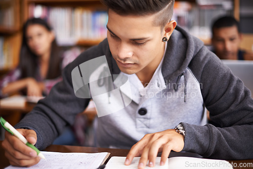 Image of Study, writing and focus with man in library for education, research and classroom quiz. College, learning and notebook with male student on university campus for knowledge, scholarship and project