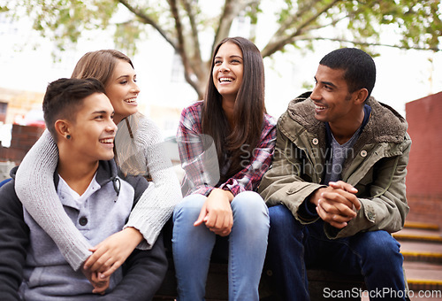 Image of University, happy and friends on campus stairs in conversation, talking and chatting outdoors. Diversity, education and happy men and women students for social bonding on school, academy and college