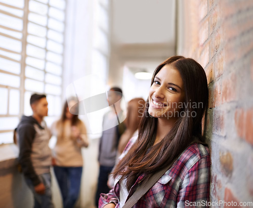 Image of Education, smile and portrait of woman in college hallway for studying, learning and scholarship. Future, happy and knowledge with student against brick wall for university, academy and campus