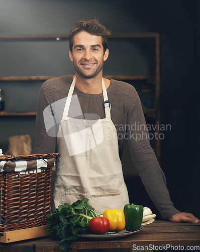 Image of Chef, smile and portrait of man in kitchen with vegetables for vegetarian meal, healthy diet or vegan nutrition. Cooking, happiness and confident male cook from Canada in restaurant or small business