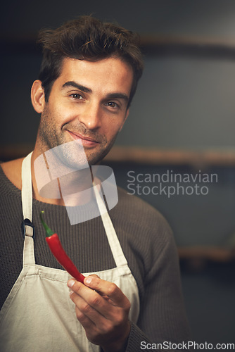 Image of Chef, chilli and portrait of man in kitchen with vegetables for vegetarian, healthy diet or vegan ingredients. Cooking, male cook holding hot pepper and food for spices from Canada in home or house.