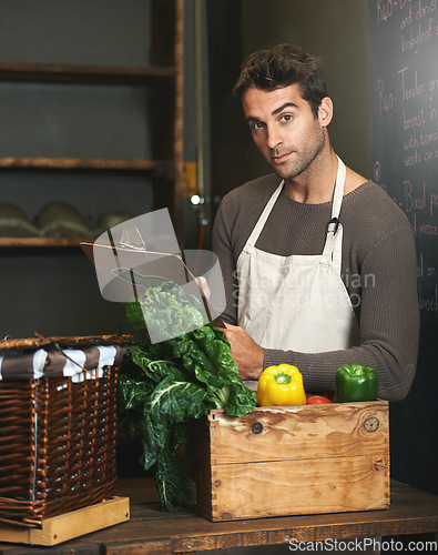 Image of Chef, checklist and portrait of man in restaurant with vegetables for vegetarian or vegan ingredients. Serious, male cook with clipboard and food from Norway for cooking in kitchen or small business.