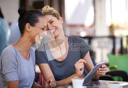 Image of Conversation, tablet and friends drinking coffee at a cafe together while browsing on social media. Happy, smile and women speaking, laughing and scrolling on a mobile at a restaurant in the city.