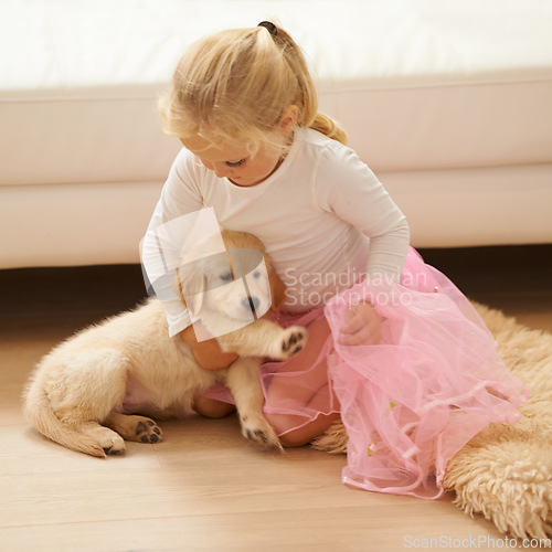 Image of Child, golden retriever or dog playing together in a happy home with love, care and development. Girl kid and animal, puppy or pet in a tutu for dress up game as friends on the living room floor