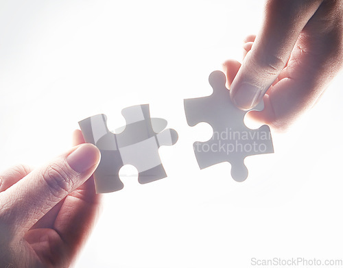 Image of Hands, puzzle and strategy for teamwork, problem solving or together for support, glow or help by white background. Team building, jigsaw or games for innovation, synergy or solution in collaboration