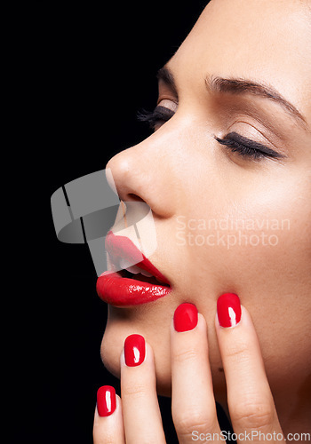 Image of Manicure, makeup and woman with red lipstick and nails in a studio with a self care pamper treatment. Cosmetic, beauty and closeup zoom of a female model with a facial routine by a black background.