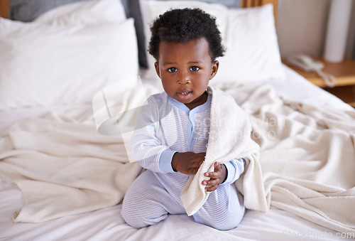 Image of Playful, portrait and baby with a blanket in bed, waking up and playing in his home. Face, sweet and african boy toddler in a bedroom curious, having fun and sweet, cute and enjoying a morning indoor