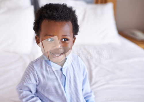 Image of Happy, curious and baby laughing in bed, waking up and playing in his home. Face, smile and african boy toddler in a bedroom cheerful, having fun and sweet, cute and playful while relaxing alone