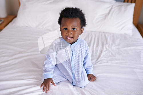 Image of Black baby boy playing in bedroom, sitting on the bed with early childhood development. African male toddler, cute curious child with growth and learning, childcare and relax at family home