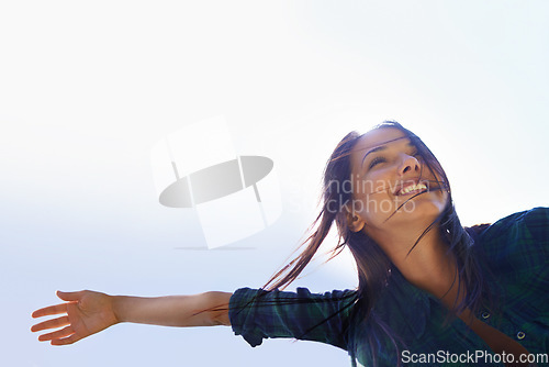 Image of Mockup, sky and arms with a woman outdoor in nature for fun, freedom or adventure in summer from below. Energy, celebrate life or wellness with a happy young female person outside with a smile