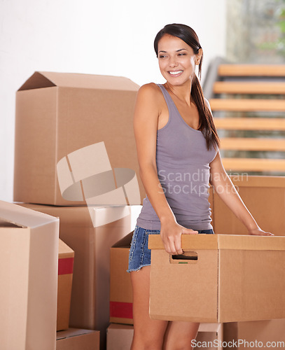 Image of Smile, young woman and packing boxes for new home owner or parcels for logistics and client moving house. Freight, cargo and lady at property with a package from a courier or shipping for real estate