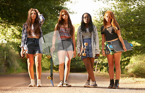 Image of Girl friends, skateboard and portrait outdoor with diversity in summer on holiday in a road. Female student, sunshine and youth skateboarding of young gen z group and teen people on vacation