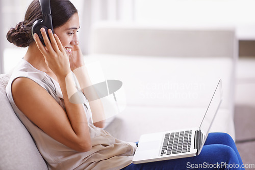 Image of Woman, laptop and headphones on sofa with smile for online education, music or learning on web in home. Student girl, computer and happy for webinar, development and listen on couch with mockup space