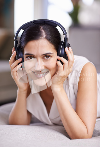 Image of Happy woman, portrait smile and headphones for music listening, free time or relaxing on sofa at home. Face of female smiling in happiness on living room couch with headset for audio sound track