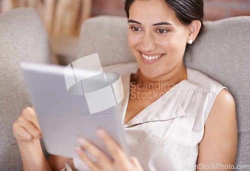 Image of Happy woman, tablet and relax for online entertainment, streaming or social media on living room sofa at home. Female relaxing with smile using technology for app or research lying on lounge couch