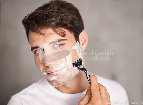 Image of Foam, shaving and portrait of man in bathroom for facial grooming, wellness and skincare at home. Health, cosmetics and male person shave beard for face hygiene, cleaning and hair removal with razor