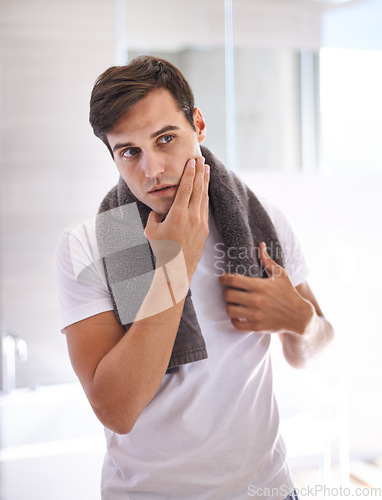 Image of Skincare, shaving and face of man in bathroom for facial grooming, wellness and cosmetics at home. Health, dermatology and serious male person for hygiene, cleaning and hair removal with beauty cream