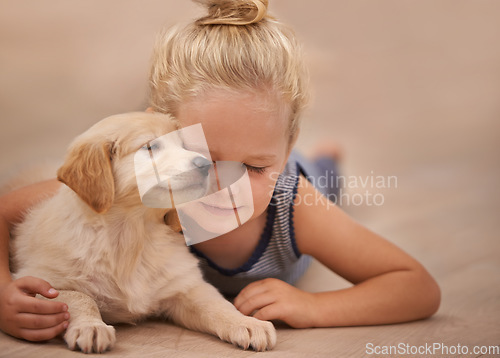 Image of Young girl hug her dog, relax with peace and calm at home with golden retriever puppy and child. Mans best friend, pet care and love with female kid and her domestic animal lying on wood floor