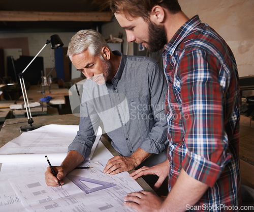 Image of Carpenter men, teamwork and drawing on paper with discussion, construction and design in workshop. Senior man, young male partner and paperwork for building, collaboration or woodworking company