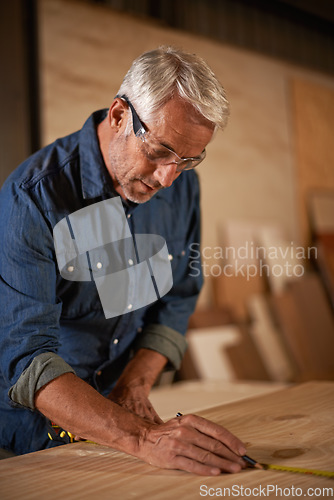 Image of Carpentry, measuring tape and man with pencil, focus and designer furniture manufacturing workshop. Creativity, small business and professional carpenter planning sustainable diy wood project design.