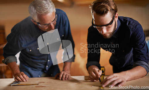 Image of Teamwork, carpenter and apprentice in workshop, wood measurement and designer furniture manufacturing. Mentorship, carpentry and men at sustainable business, teaching and learning with design project