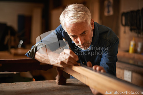 Image of Carpentry, furniture restoration and man with pencil, table and antique wood manufacturing workshop. Creativity, small business and focus, professional carpenter working on retro wood project design.