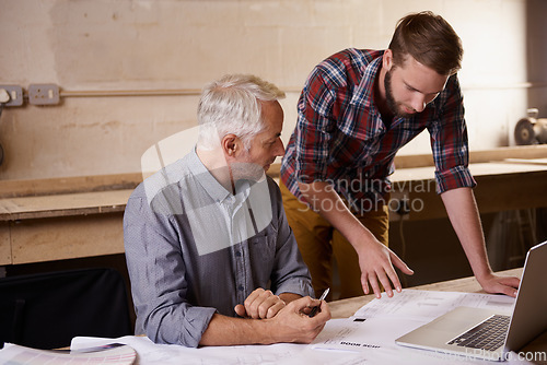 Image of Architecture, teamwork and father and son with blueprint in workshop for collaboration on laptop. Senior engineer, men and paperwork of trainee or apprentice working on design and plan with mentor.