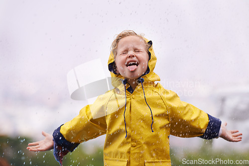 Image of Winter, raincoat and a girl tasting the rain outdoor alone, having fun during the cold season. Kids, water or wet with an adorable little female child playing arms outstretched outside in the day