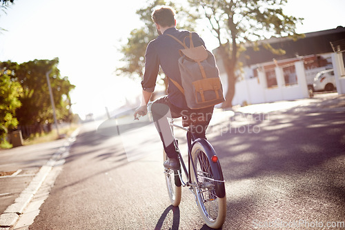 Image of Bicycle, transport and back of man in street on lens flare for exercise, commute and cycling in morning. Travel, city and male cyclist on bike for eco friendly traveling, carbon footprint and journey