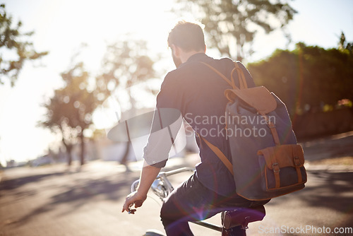 Image of Bicycle, travel and back of man in street with lens flare for exercise, commute and cycling in morning. Transport, city and male cyclist on bike for eco friendly traveling, carbon neutral and journey