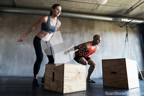 Image of Gym, couple and exercise with box jump for training, workout and intense cardio on wall background. Health, fitness and people at a sports center for wellness, performance and endurance challenge