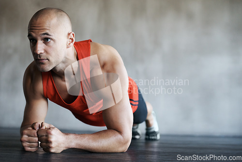 Image of Fitness, man and plank in workout, exercise or training for strong core, abs or determination at gym. Serious, fit and confident male personal trainer working on abdominal muscle for healthy wellness