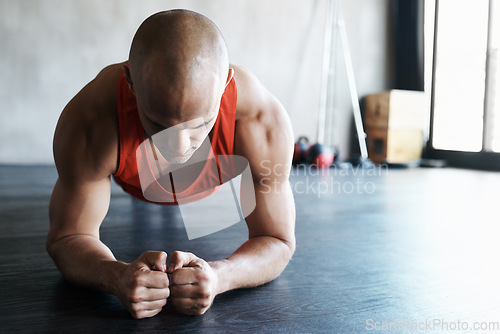 Image of Gym, focus and man doing floor plank exercise, health performance or core strength building for bodybuilding. Training, commitment and person concentrate on fitness, muscle development or workout