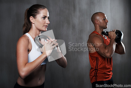 Image of Fitness, people and weightlifting standing with kettlebell for workout or exercise together at gym. Serious man and woman lifting weight for strong exercising, power or muscle in training indoors