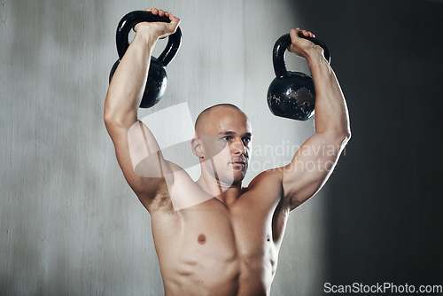 Image of Fitness, man and weightlifting with kettlebell for arm workout or intense exercise at the gym. Serious muscular male lifting weight for strong exercising, power or strength training in bodybuilding