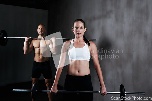 Image of Fitness, people and weightlifting with barbell for exercise, bodybuilding or workout at gym. Portrait of fit, active and strong woman and man lifting weight for intense strength, muscle or training