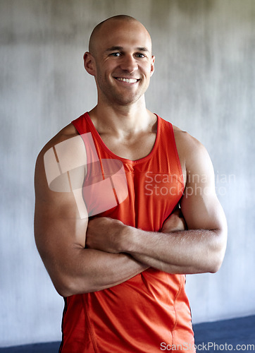 Image of Happy man, fitness and portrait smile with arms crossed in confidence for workout, exercise or training at gym. Strong muscular male and confident personal trainer, leader or coach in bodybuilding
