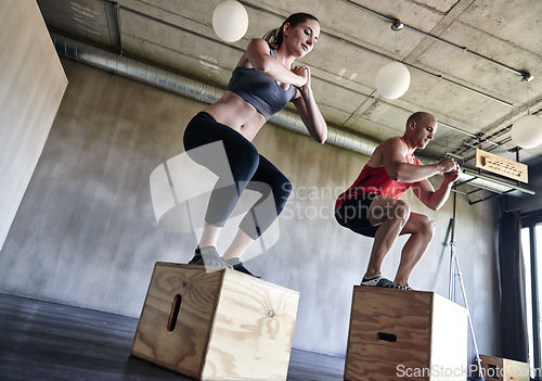 Image of Gym, fitness and friends with jump box for training, workout and intense cardio on wall background. Jumping, exercise and people at a sports center for wellness, performance and endurance challenge