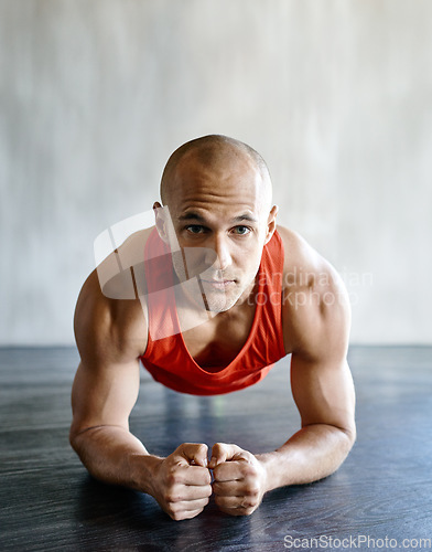 Image of Gym floor, portrait and fitness man focus on plank exercise, health motivation or core strength building for bodybuilding. Training, hard work commitment and person doing muscle development workout