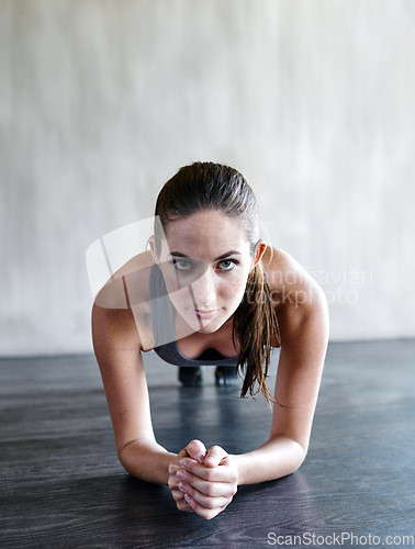 Image of Gym floor, portrait and woman focus on plank exercise, health motivation or core muscle building. Balance challenge, hard work mindset and person doing body development workout in fitness studio