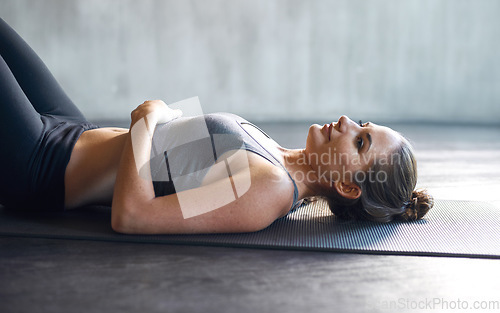 Image of Gym, floor and tired woman relax after training, cardio and intense workout routine. Fitness, fatigue and girl on the ground at sports center after pilates, exercise or yoga for health and wellness