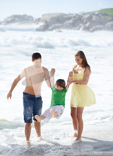 Image of Family, summer and swinging child at beach for fun, travel or holiday with a smile in water. A man, woman and kid or son playing together on vacation at sea with waves, love and happiness outdoor