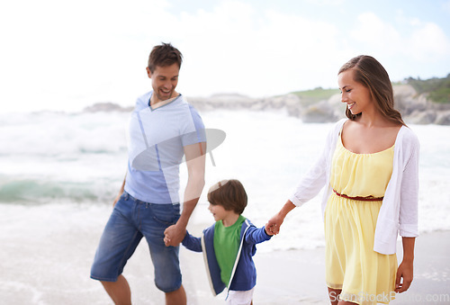 Image of Family, child and holding hands while walking at beach for travel, fun or holiday in summer with a smile. Man, woman and kid or son walk together on vacation at sea with happiness, love and care