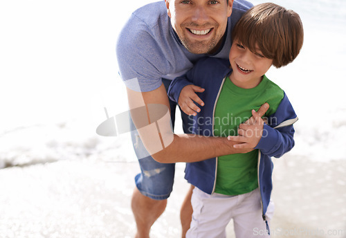 Image of Father, child or family fun at beach for travel or holiday in summer with a smile, love and hug. A man and kid or son playing and laughing together on vacation at sea with sunshine and happiness