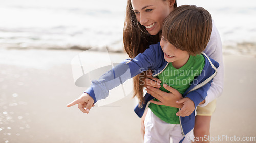 Image of Mother, child and pointing outdoor at beach for family travel or holiday in summer with a smile and fun. A woman and kid or son playing together on vacation at sea with love, care and happiness